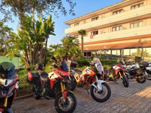 uma fila de motocicletas estacionadas em frente a um edifício em Green Sporting Club Hotel em Alghero