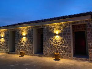 a stone building with lights on it at night at Agape Rose Hotel in Tivat