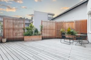 a patio with a fence and two chairs and a table at MischMasch Appartement in Deutschlandsberg