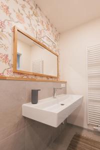 W łazience znajduje się biała umywalka i lustro. w obiekcie MischMasch Appartement w mieście Deutschlandsberg