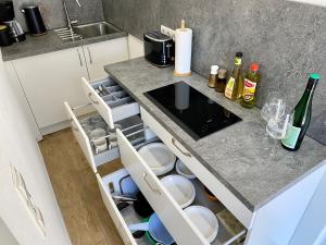 eine Küche mit einer offenen Schublade mit Flaschen und Geschirr in der Unterkunft City Apartment in Bornheim - Köln Bonn Phantasialand in Bornheim + 10 Fotos