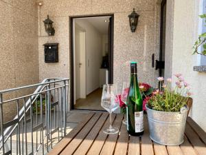 - une bouteille de vin et deux verres sur une terrasse couverte dans l'établissement City Apartment in Bornheim - Köln Bonn Phantasialand, à Bornheim