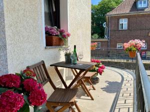 Ein Tisch und zwei Stühle auf einem Balkon mit Blumen in der Unterkunft City Apartment in Bornheim - Köln Bonn Phantasialand in Bornheim