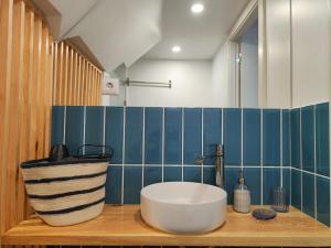 a bathroom with a large white tub on a wooden counter at Blue Essence Apartment - Central in Coimbra