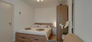 a white bedroom with a bed and a chair at Holiday Home Peran in Grebaštica +88 photos