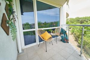 balcón con 2 sillas y mesa con almohada amarilla en Design Studio in Atlantis Resort&SPA, Burgas Airport en Burgas