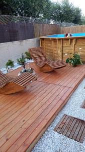 una terraza de madera con piscina y piscina en B&B Tra colline marchigiane - sauna e piscina en San Giorgio di Pesaro