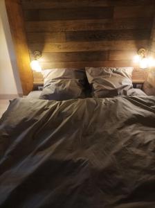 an unmade bed with a wooden headboard and two pillows at Chorni vivtsy in Chernivtsi