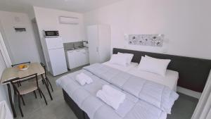a bedroom with a large white bed with two pillows at STAY Napa Living Studios in Ayia Napa
