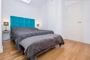 a bedroom with two beds and a blue headboard at BHost - Historic Center Pastor in Málaga