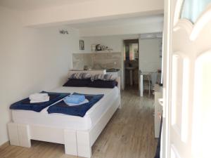 a bedroom with a large white bed with blue sheets at New studio app for 2 in Babino Polje