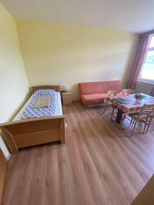 Kleines Zimmer mit einem Bett und einem Tisch in der Unterkunft Ferienwohnung Goldener Drache in Adorf