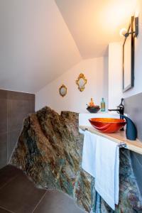 - une salle de bains avec un lit et un bol sur un comptoir dans l'établissement REVO Apartaments - Gualzi63 the Best View, à Sondrio