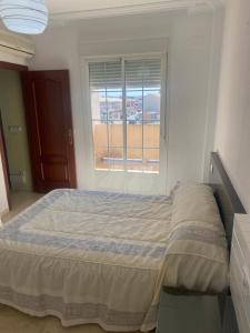 een slaapkamer met een bed en een raam bij Casa hasta 6 personas in Carraca