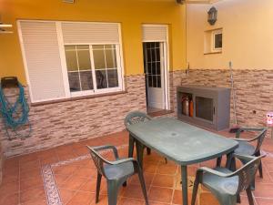 een patio met een tafel en stoelen en een open haard bij Casa hasta 6 personas in Carraca