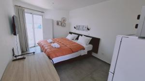 ein Schlafzimmer mit einem Bett mit einer orangefarbenen Decke in der Unterkunft STAY Napa Living Studios in Ayia Napa