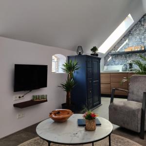a living room with a tv and a couch and a table at B & B Diever in Diever