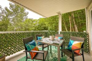 un patio con mesa, sillas y una valla en Le PanoramiK by Gestion ELITE, en Mont-Tremblant