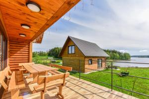 um deque de madeira com uma mesa e uma casa em Nijolės sodyba em Aukstadvaris