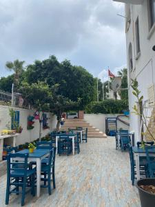 a row of blue tables and chairs on a patio at ÇAMLIK PANSİYON in Antalya