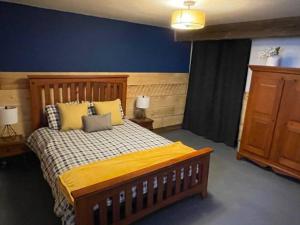 um quarto com uma cama e uma parede azul em Chalet de l'Ours bord Rivière - Lit King size - Petit Déjeuner Bio - Table de Pool em Saint-Alexis-des-Monts