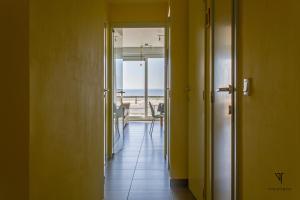 - un couloir offrant une vue sur la plage depuis une maison dans l'établissement L'arc en ciel, à Bray-Dunes