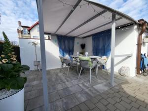 a patio with a table and chairs under a pergola at Dom Jastarnia Apartamenty in Jastarnia