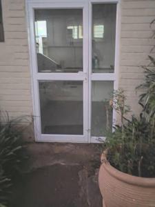 a door with a window on the side of a house at Cottage near Lagoon beach in Durban in Durban