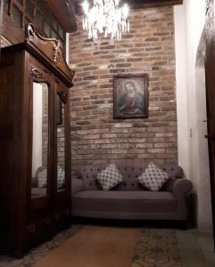 a couch in a room with a brick wall at Hotel Boutique Posada XVII in Puebla