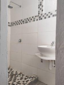 a white bathroom with a sink and a shower at Cottage near Lagoon beach in Durban in Durban