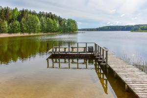 a dock on a body of water with trees at Nijolės sodyba in Aukštadvaris