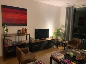 sala de estar con TV de pantalla plana y sillas en Excelente departamento en la Condesa en Ciudad de México