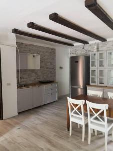 een keuken met een tafel en stoelen in een kamer bij Attico con terrazzo Gallipoli in Galatina