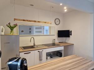 a kitchen with a sink and a counter top at Dom Jastarnia Apartamenty in Jastarnia