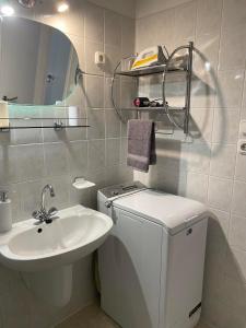 a bathroom with a sink and a toilet and a mirror at Víztorony Apartmanok Siófok in Siófok