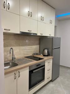 a kitchen with white cabinets and a stainless steel refrigerator at Gargovic Apartments in Budva