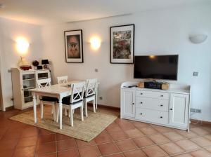 a dining room with a white table and a tv at Ferienwohnung Suedterrasse in Dewichow