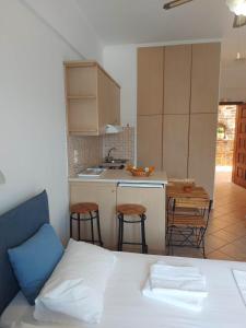 1 dormitorio con 1 cama y cocina con mesa en Anarrousa Studios & Apartments, en Evdilos