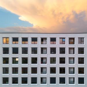 a facade of a white office building at sunset at 107 Dreams in Tirana