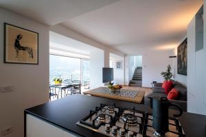 a kitchen with a stove top oven next to a living room at REVO Apartaments - Gualzi63 the Best View in Sondrio