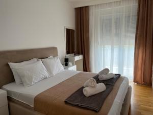 a bedroom with two towels on a bed with a window at Gargovic Apartments in Budva