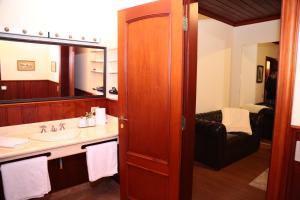 La salle de bains est pourvue d'un lavabo et d'un miroir. dans l'établissement Pousada Miraflores, à Campos do Jordão