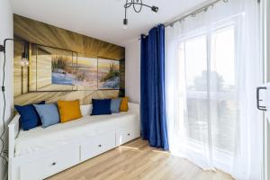 a bedroom with a bed with blue and yellow pillows at Apartament Baltic Dream ProstyWynajem Gdańsk Brzeźno in Gdańsk