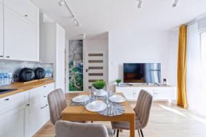 a kitchen and dining room with a wooden table and chairs at Apartament Baltic Dream ProstyWynajem Gdańsk Brzeźno in Gdańsk