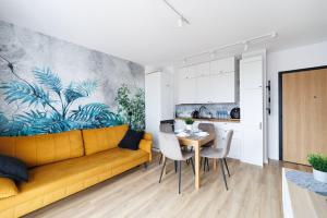 a living room with a yellow couch and a table at Apartament Baltic Dream ProstyWynajem Gdańsk Brzeźno in Gdańsk +10 photos