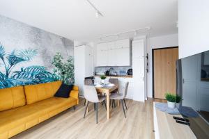 a living room with a yellow couch and a table at Apartament Baltic Dream ProstyWynajem Gdańsk Brzeźno in Gdańsk