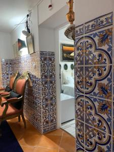 a bathroom with a blue and white patterned wall at Vila Aurora in Luso