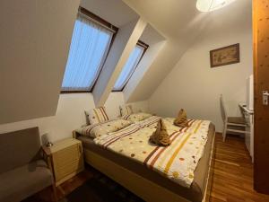 a bedroom with two cats sitting on a bed at Mol-Ker-Vill Apartment in Lenti