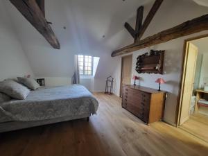 a bedroom with a bed and a dresser and a window at Manoir de La Garaye - Suite Parentale in Taden