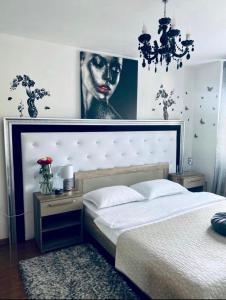 - une chambre avec un lit et une photo de femme dans l'établissement Apartament Lux Crialy - self check-in, à Timişoara